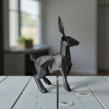 Minimalist low poly reindeer displayed on white shelf in bright interior