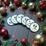 Six snowman coasters with different faces stacked in matching holder