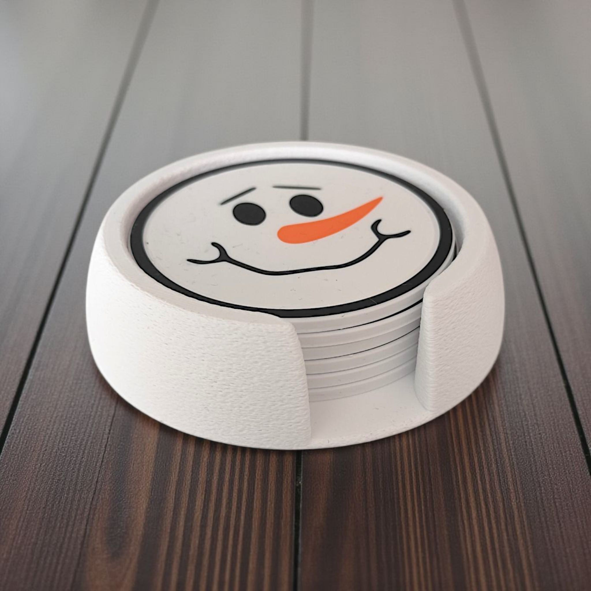 Six snowman coasters with different faces stacked in matching holder