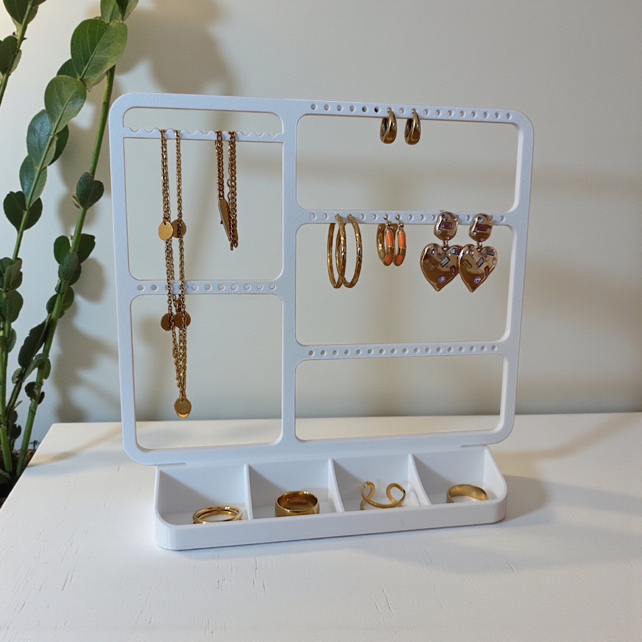 Jewelry organizer mounted above a dresser with earrings and delicate necklaces displayed