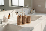 Little Family toothbrush holder set styled on a bathroom counter with soap and towels