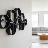 Three modular round shelves arranged vertically on a white wall displaying small objects