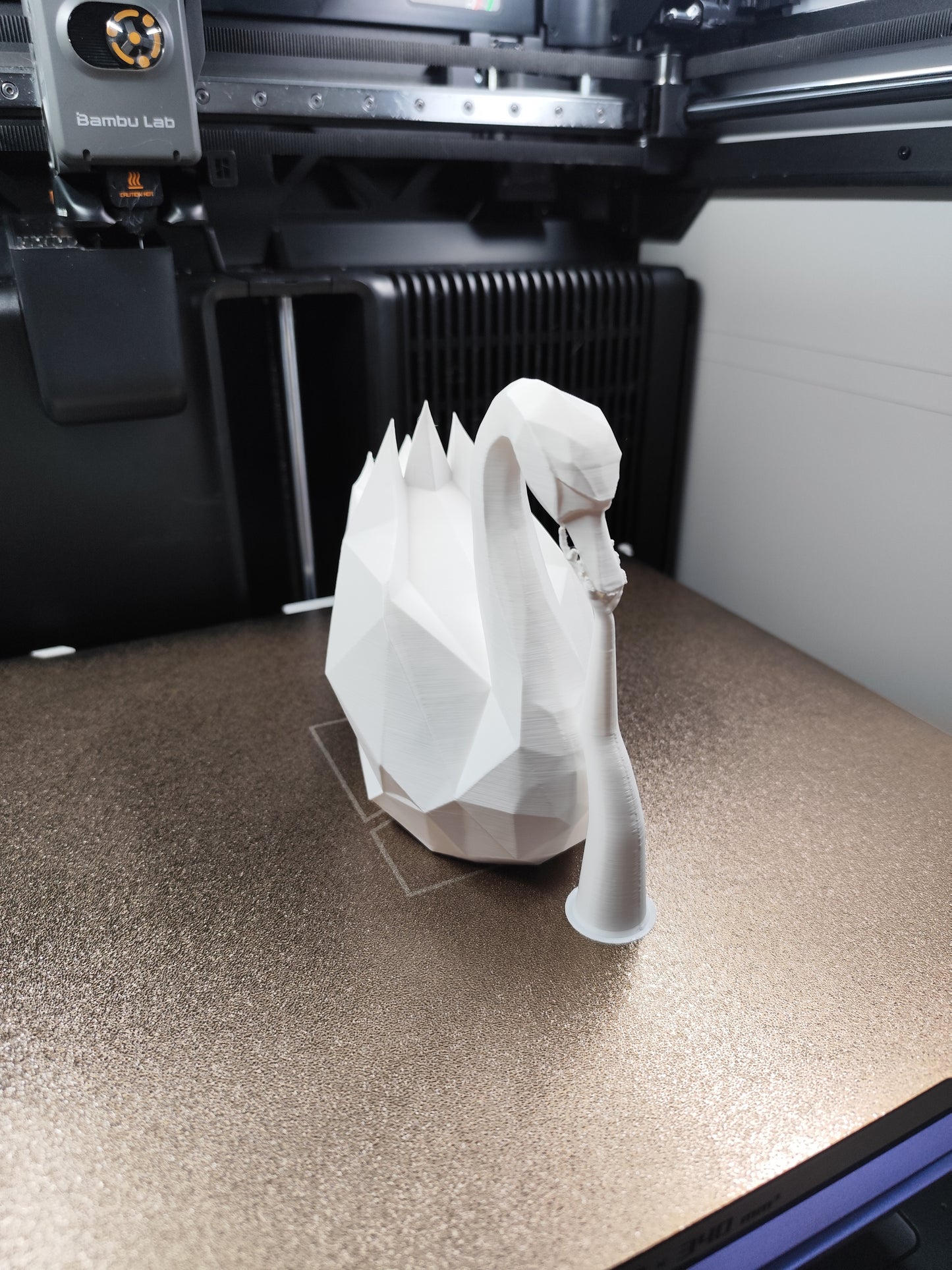 White low poly swan sculpture with angular geometric form, close-up detail
