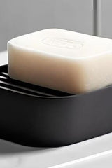 Minimalist soap holder with sloped surface, white finish, close-up view
