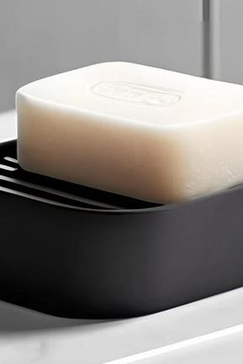 Minimalist soap holder with sloped surface, white finish, close-up view