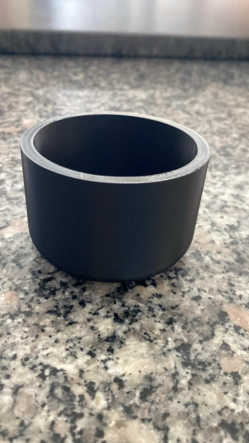 Minimalist round plant pot on a wooden shelf with succulent inside