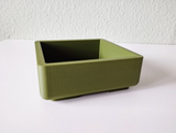 Square bonsai pot displayed on windowsill with small green plant inside