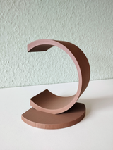 White circular bookend holding stack of books on wooden shelf
