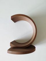 White circular bookend holding stack of books on wooden shelf