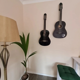 Electric guitar mounted on white wall using discreet minimalist holder