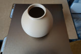 Close-up of minimalist round vase showing smooth spherical form and clean surface