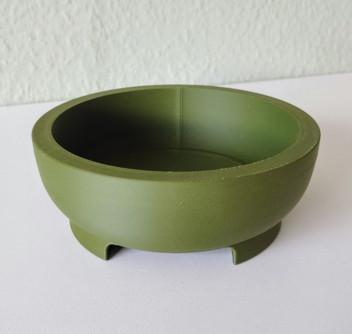 Close-up of round bonsai pot showing clean geometric form with integrated foot