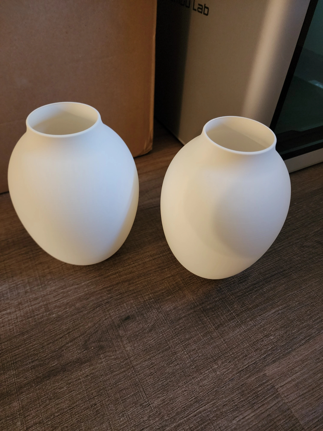 Modern amphora vase displayed on white shelf in minimalist interior