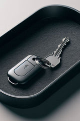 Minimalist round key tray in soft neutral tone, close-up view showing smooth flat surface