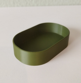 Minimalist round key tray in soft neutral tone, close-up view showing smooth flat surface