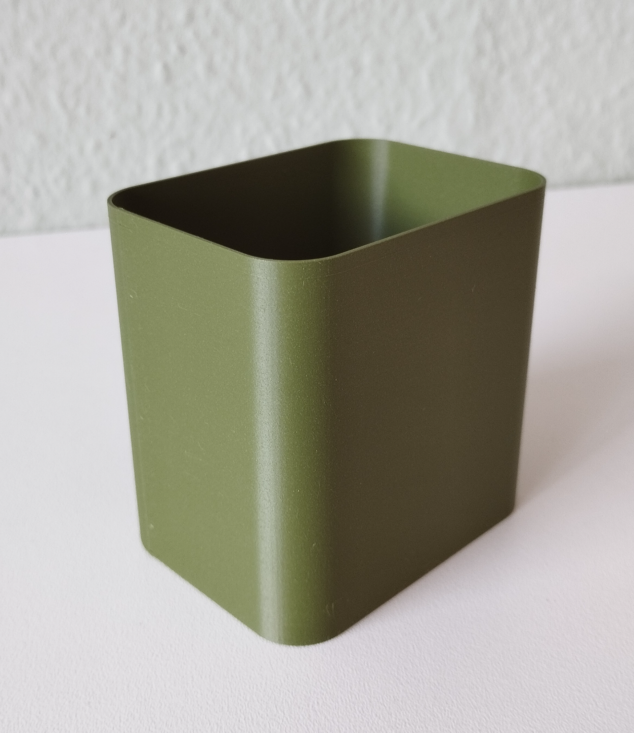 Minimalist pencil holder on desk with pens and notebooks in styled setting