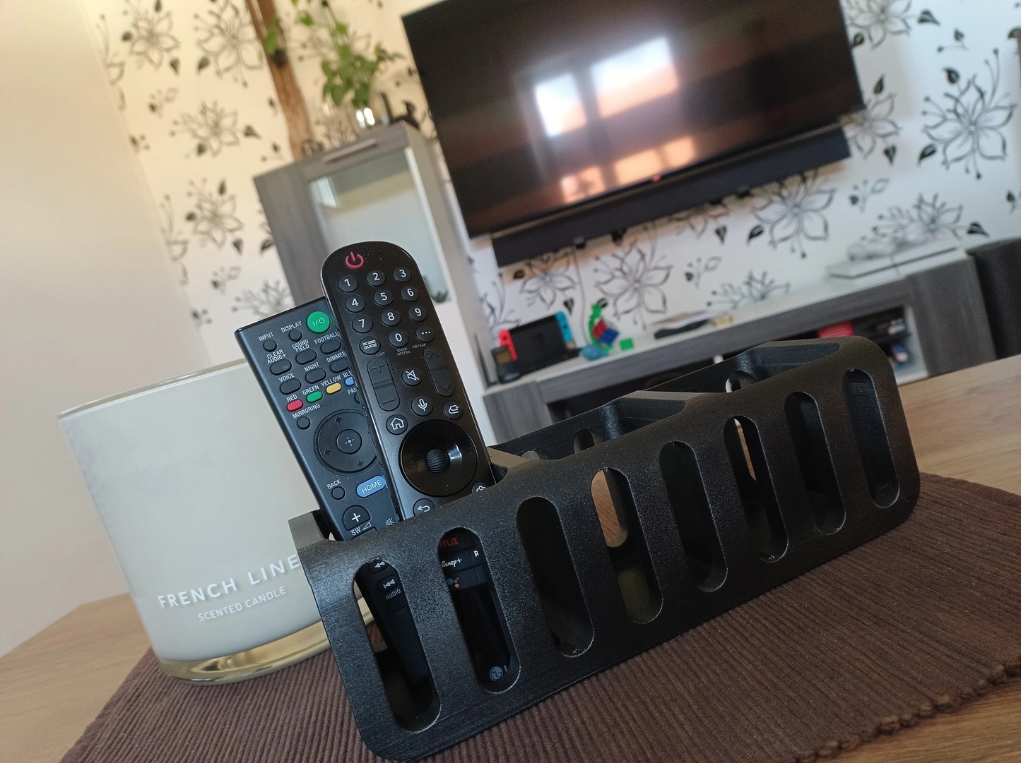 Remote control holder styled on a living room side table next to a plant