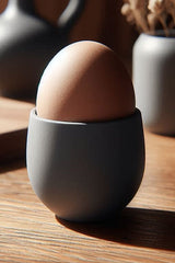 Modern egg cup in white, angled close-up showing clean tapered form