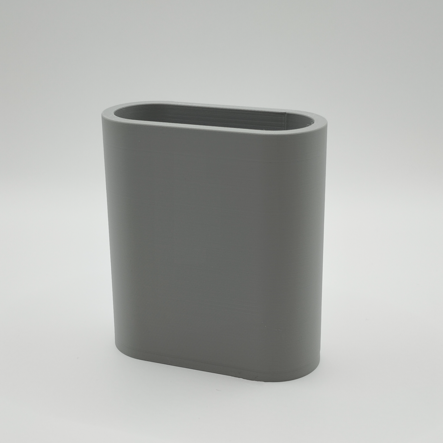 White minimalist pencil holder on wooden desk with pens and pencils inside
