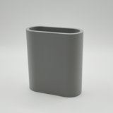 White minimalist pencil holder on wooden desk with pens and pencils inside