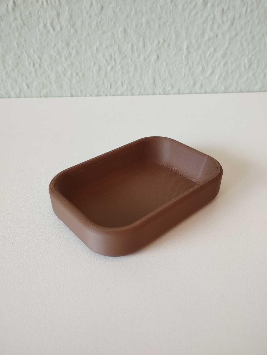 Modern key tray in soft neutral tone, close-up of smooth surface