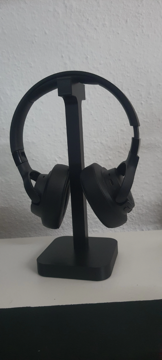 Headphone stand displayed on desk next to monitor and desk lamp