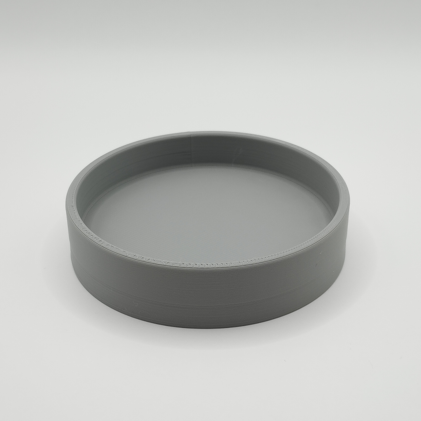 Round key tray styled on entryway console with keys and small objects inside