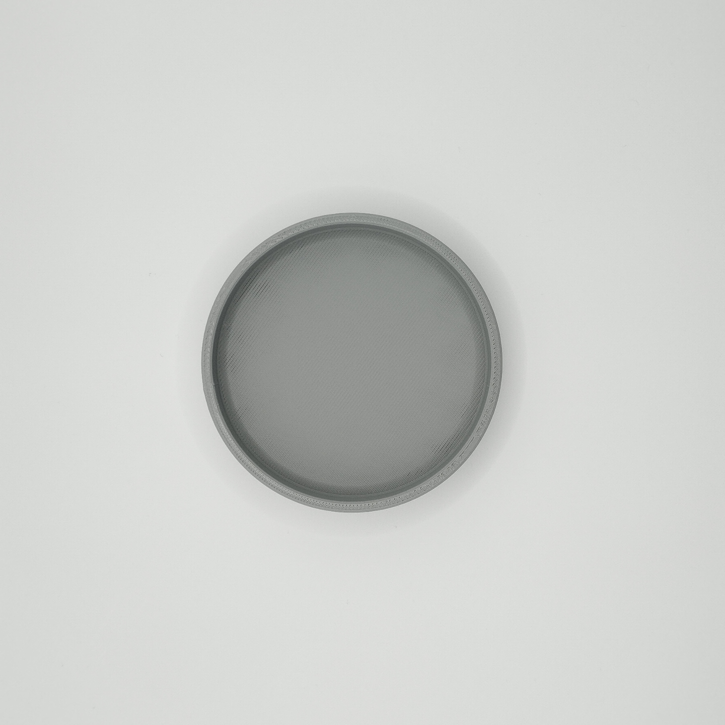 Close detail of round key tray surface showing minimalist geometric form