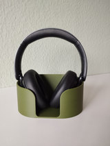 Headphone stand holding over-ear headphones on modern desk with workspace