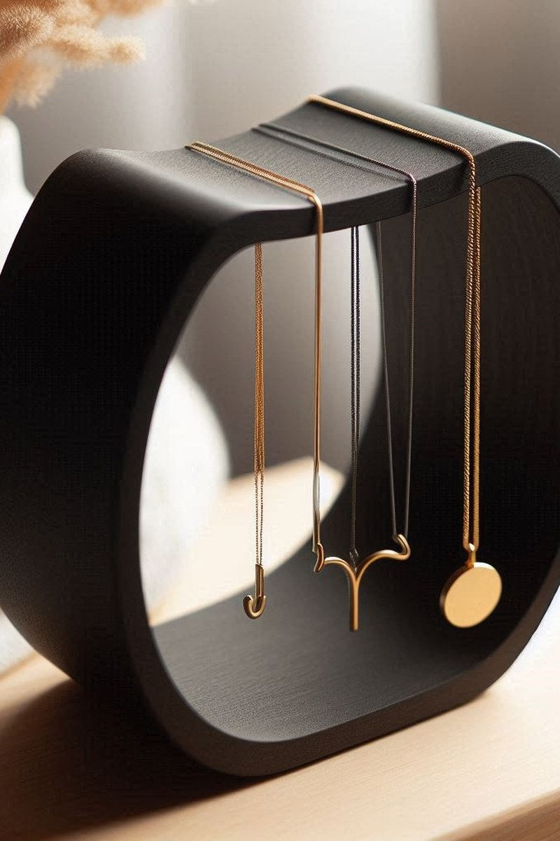 Curved necklace holder with delicate chain draped across its surface