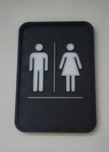 Detail of the toilet sign's crisp typography and neutral finish