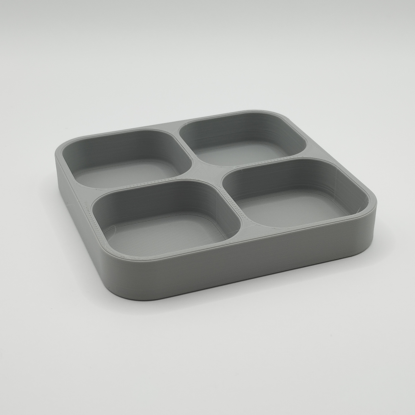 Quadruple key tray styled on a light wood shelf with keys inside