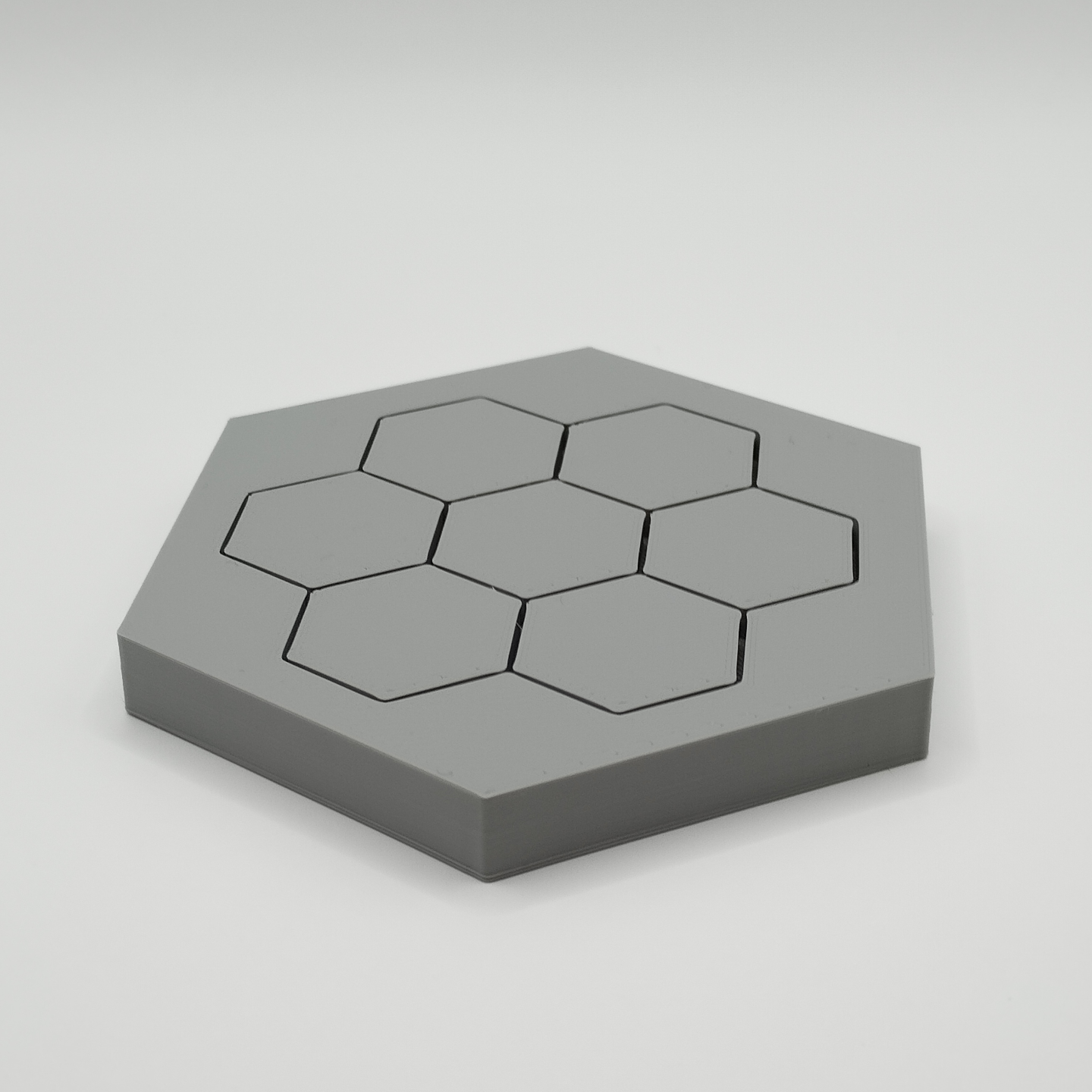 Minimalist hexagonal coasters arranged on a wooden table with a coffee cup