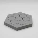Minimalist hexagonal coasters arranged on a wooden table with a coffee cup
