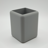 Minimalist pencil holder on desk with writing tools and notebook