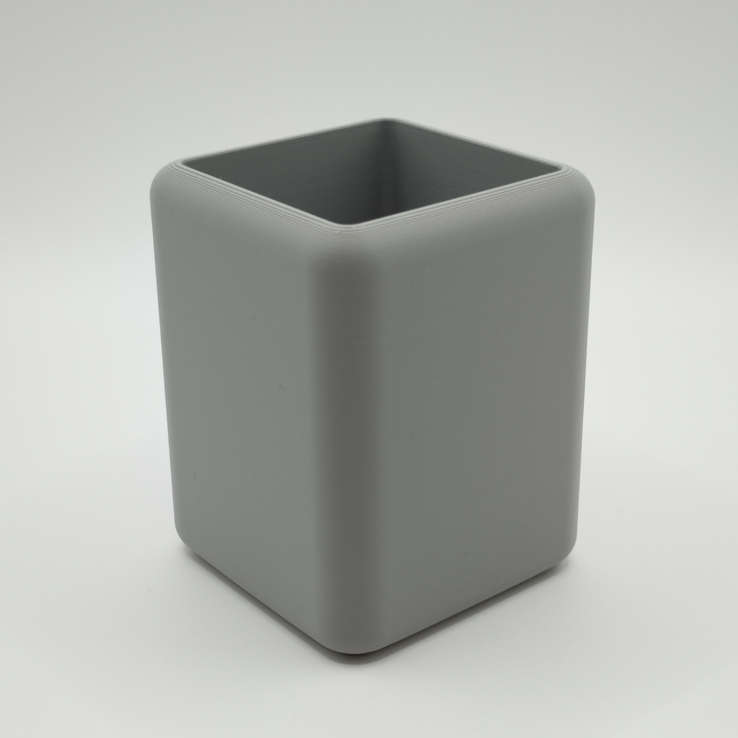 Minimalist pencil holder on desk with writing tools and notebook