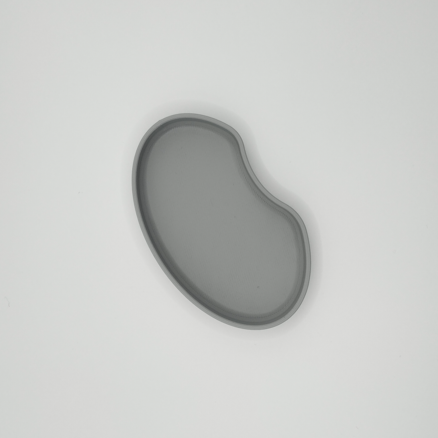 Detail view of the kidney tray's flowing edge and minimalist silhouette