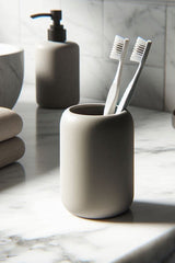 White rounded toothbrush holder with toothbrush and paste tube inside