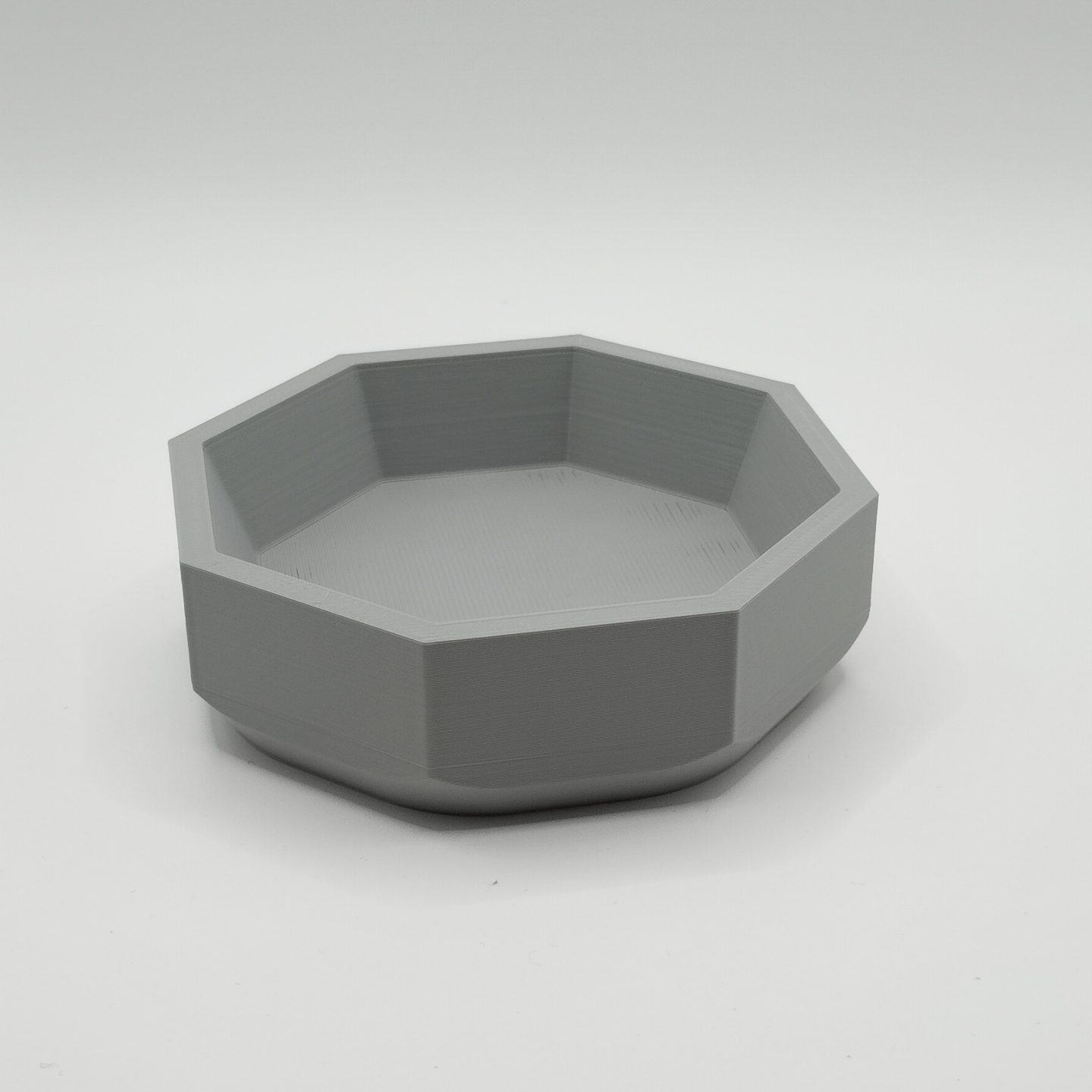 Minimalist geometric bowl displayed on wooden shelf in modern interior