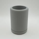 Minimalist round pencil holder on wooden desk with sketching supplies and open notebook