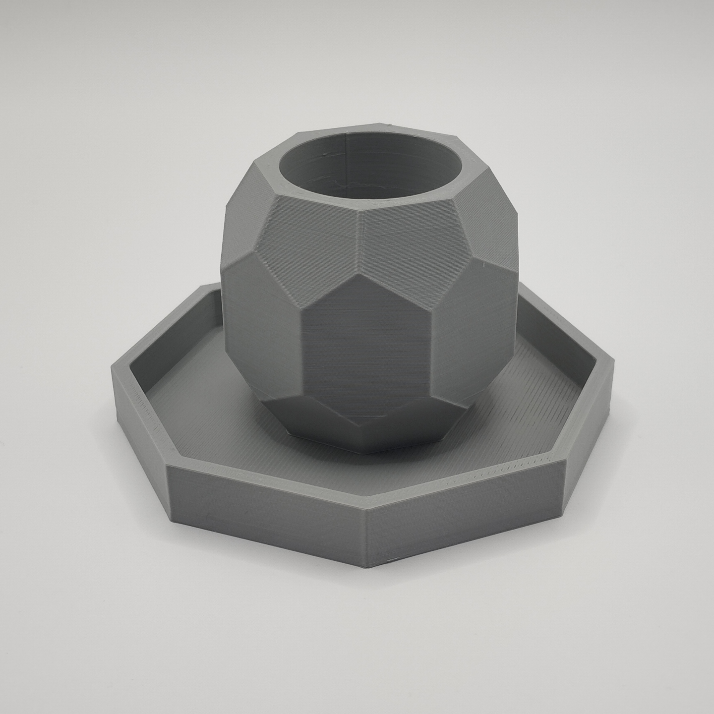 Octagonal candle holder with coaster on white wooden table