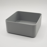 White minimalist square bowl caddy on wooden coffee table with remote and keys