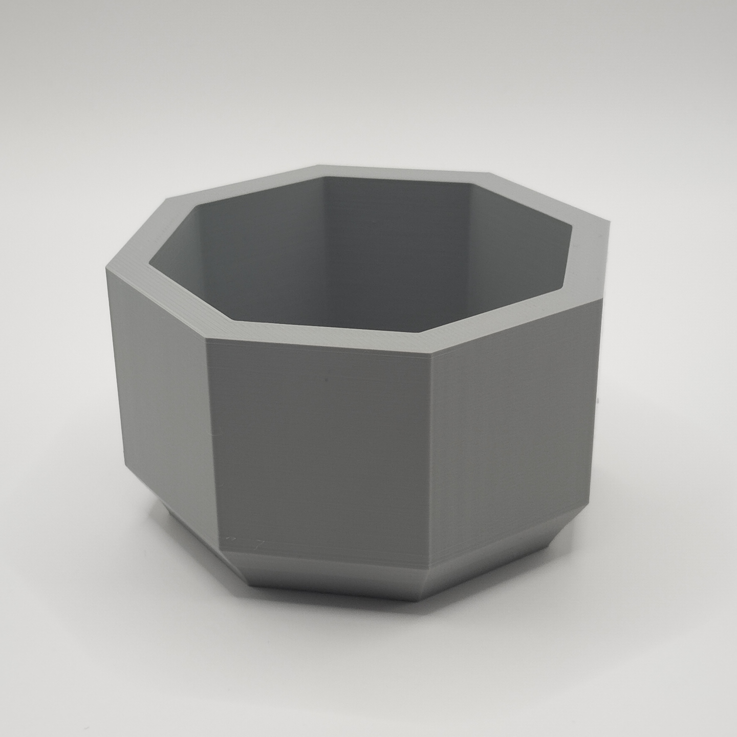 Detail of the eight-sided edge of the minimalist planter catching soft light