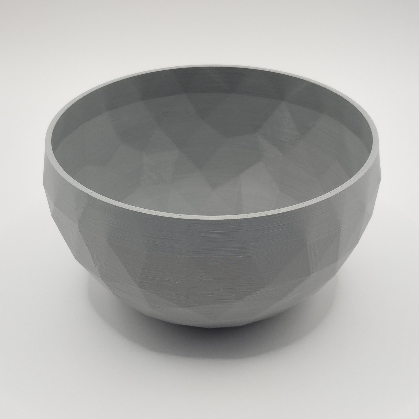 Low poly designer bowl displayed on a minimalist shelf with neutral decor