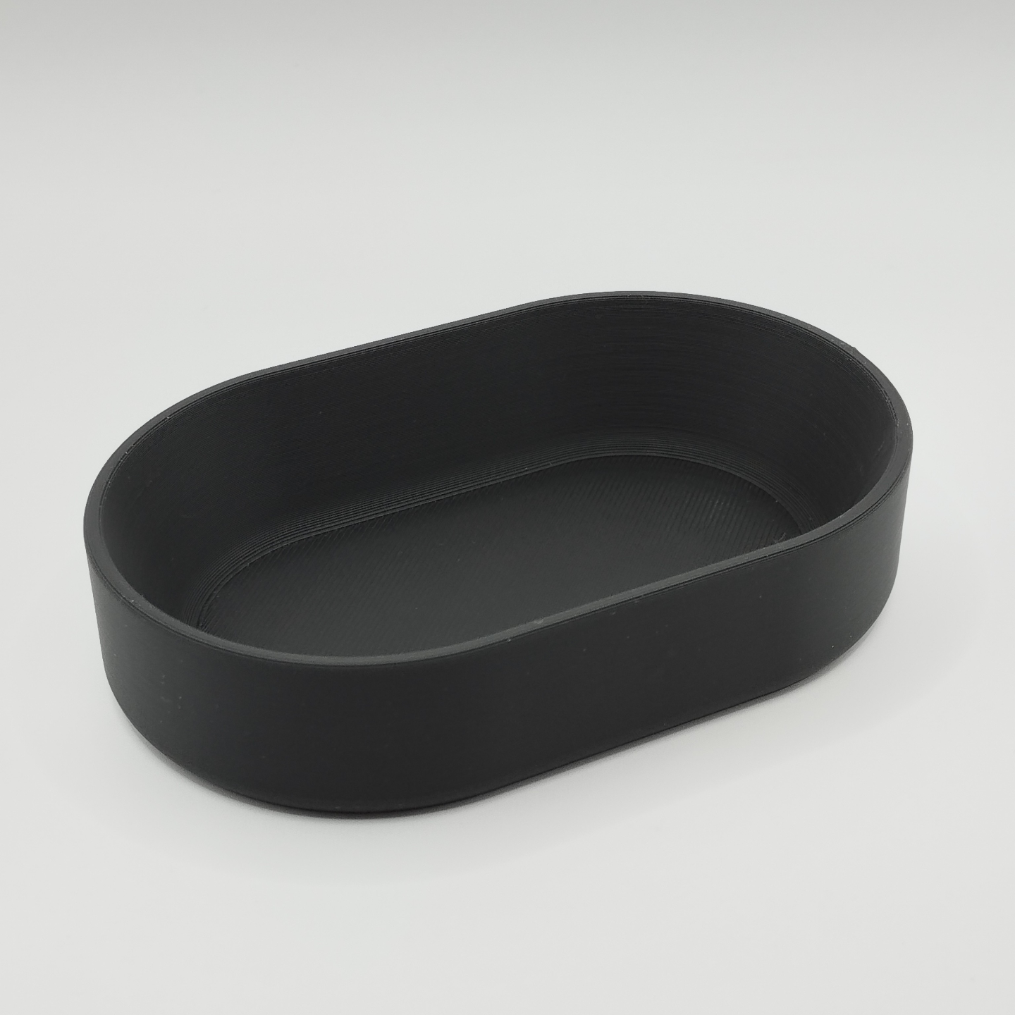 Oval tray on entryway table holding keys and coins, styled with minimalist home decor