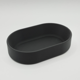 Oval tray on entryway table holding keys and coins, styled with minimalist home decor