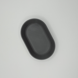 Close-up detail of the curved rim of the oval tray, catching soft light
