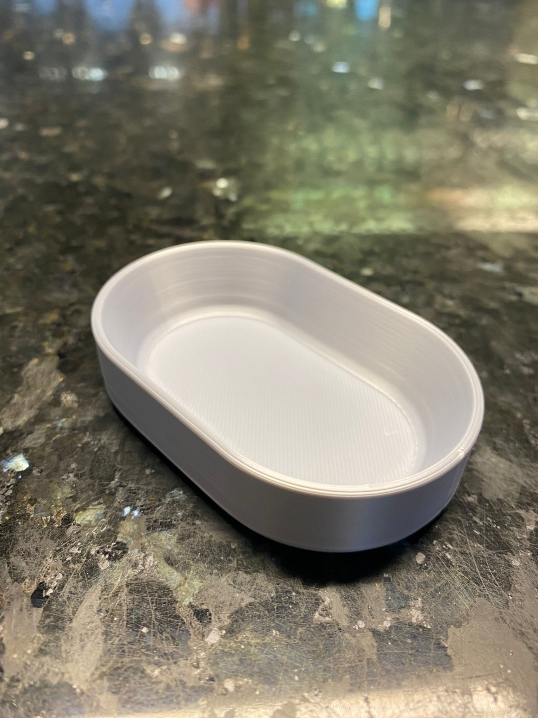 Overhead view of oval catch-all tray in natural light, showing its clean edges and curved form