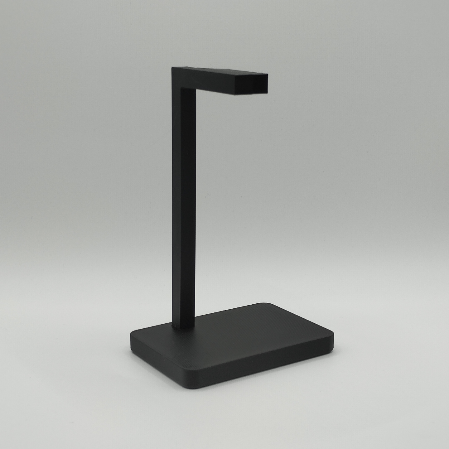 Minimalist headphone stand holding gaming headset on modern office desk