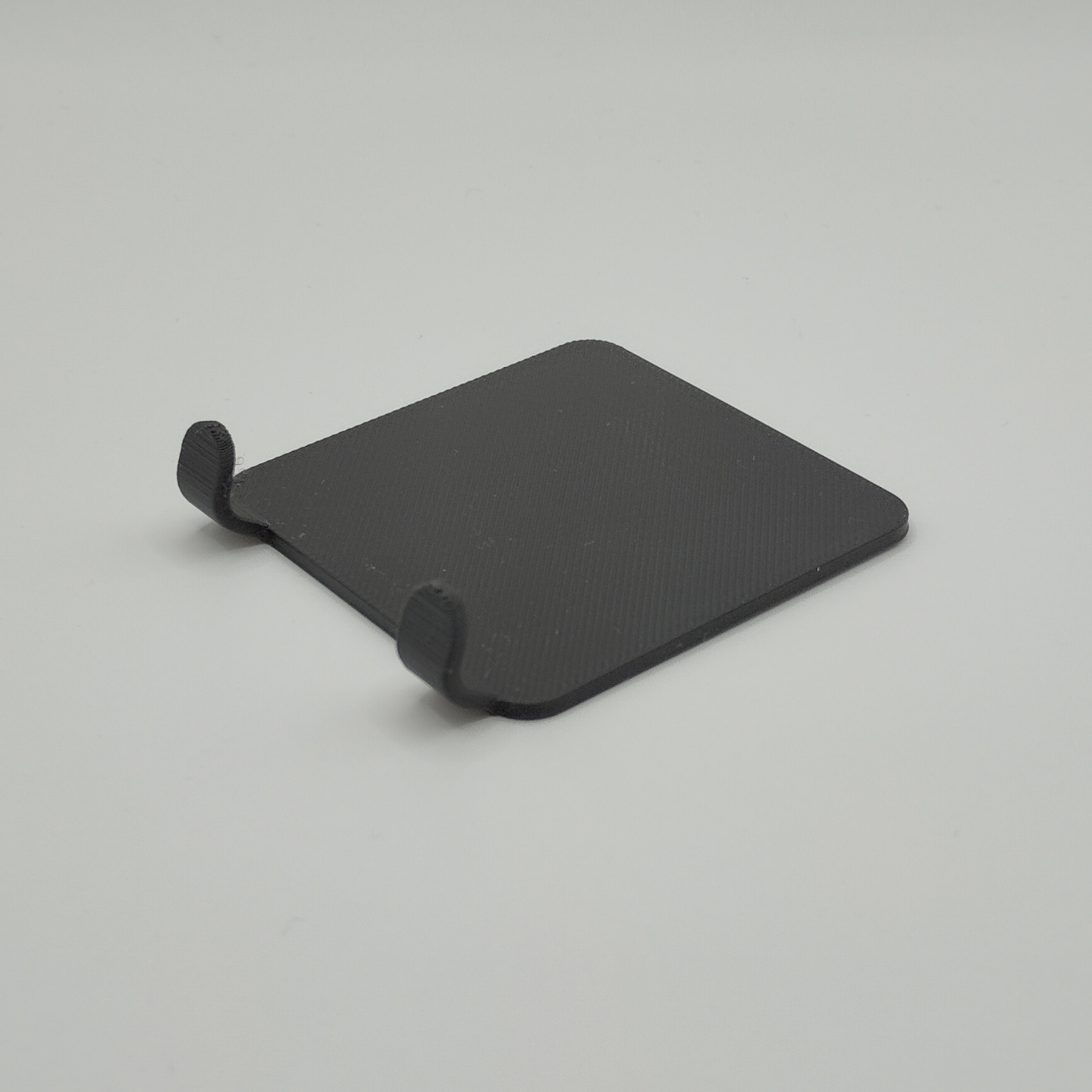 Razor holder mounted on bathroom wall with razor hanging, styled with white towel